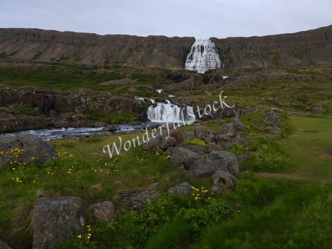 Chute d'eau à Hæstahjallafoss, Islande, entourée de rochers et de verdure.