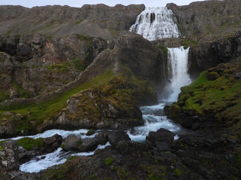 Cascade Hæstahjallafoss entourée de rochers et de verdure, Islande.