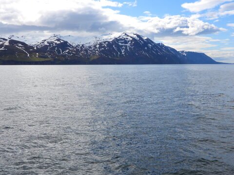 Montagnes enneigées surplombant la mer à Húsavík, Islande.