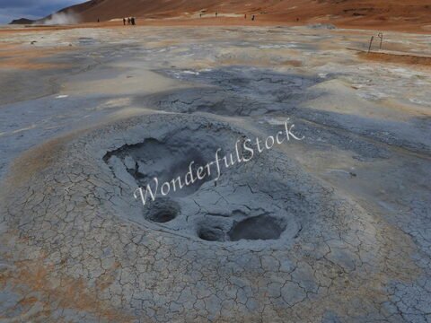 Terrains géothermiques avec des formations de boues à Hverir, Islande. Fumerolles et sol craquelé.