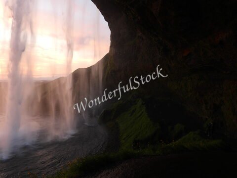 Chute d'eau Seljalandsfoss en Islande, avec des parois rocheuses et de la verdure environnante.