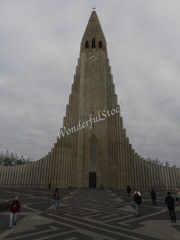 Édifice de la Hallgrímskirkja à Reykjavík, Islande, avec des motifs géométriques au sol et des nuages dans le ciel.
