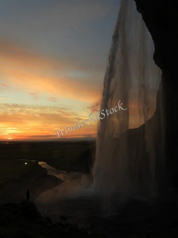 Seljalandsfoss en Islande, chute d'eau majestueuse au coucher du soleil, avec un ruisseau en contrebas.