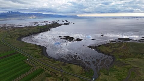 Vue aérienne de la côte islandaise avec des zones humides et des champs verdoyants en Islande.