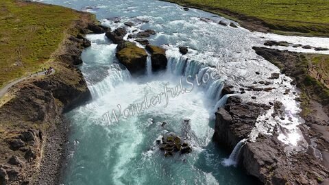 Cascades de Goðafoss en Islande, avec des eaux tumultueuses et des formations rocheuses visibles au bord de la rivière.