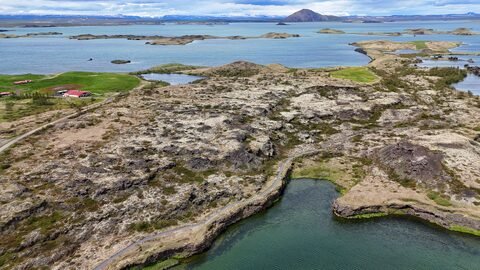 Vue aérienne des Skútustaðagígar en Islande, avec des formations rocheuses et des plans d'eau.