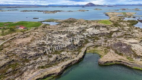 Vue aérienne des Skútustaðagígar en Islande, avec des formations rocheuses et des plans d'eau.
