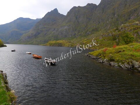 Bateaux amarrés sur un lac entouré de montagnes en Norvège.