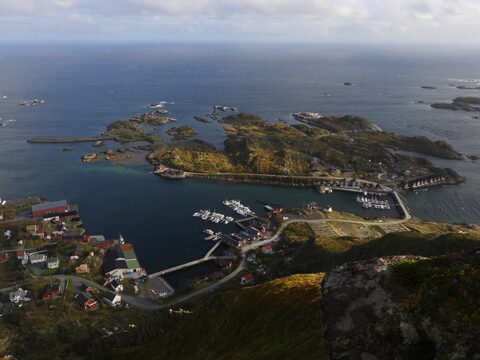 Vue sur le port et les îles de Reinebringen, en Norvège, avec des bateaux amarrés et des maisons colorées sur la côte.