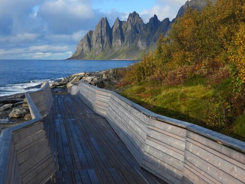 Sentier en bois menant à la mer, avec des montagnes à Tungeneset, Norvège.