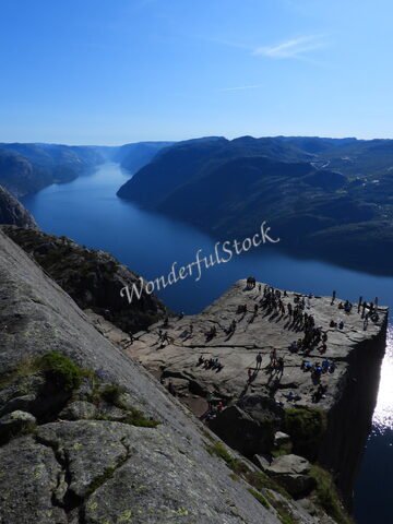 Plateau rocheux avec des visiteurs, surplombant un fjord, à Preikestolen, en Norvège.