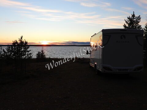 Camping-car au bord de l'eau avec un coucher de soleil, Finlande.