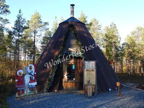 Un bâtiment en forme de tipi décoré, entouré de forêts, à Rovaniemi, Finlande.