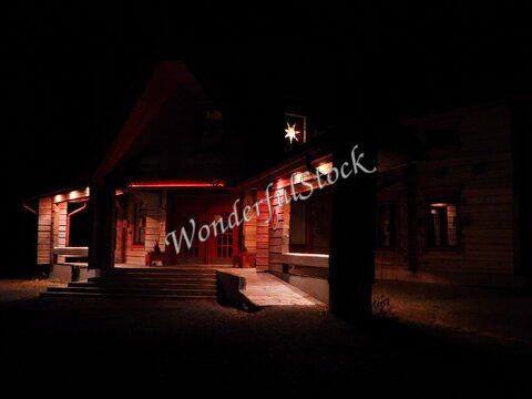 Maison en bois éclairée avec un décor lumineux, située à Rovaniemi, Finlande.