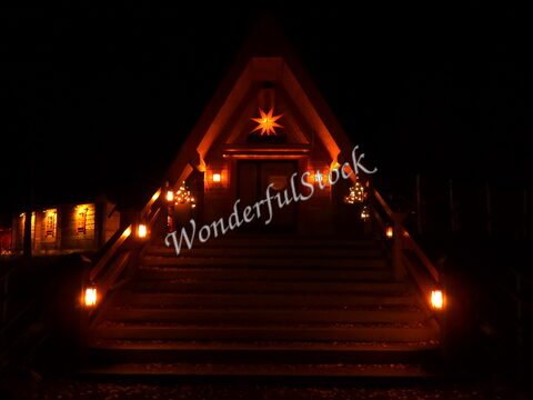 Entrée d'un bâtiment illuminé avec des lanternes, à Rovaniemi, Finlande, avec une étoile décorative au-dessus de la porte.