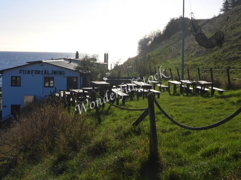 Fiskförsäljning avec des tables en bois et une vue sur la mer, Suède.