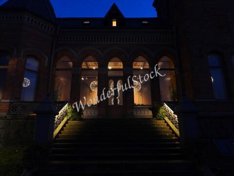 Entrée d'un bâtiment avec des escaliers illuminés, Stockholm, Suède, et des lampes décoratives visibles à travers les fenêtres.