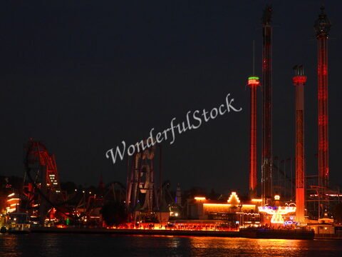 L'attraction illuminée de Grona Lund à Stockholm, Suède, avec des manèges et des lumières vives sur fond nocturne.