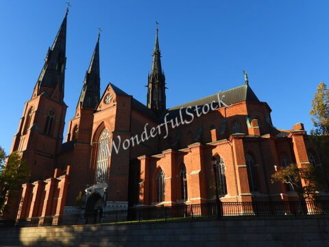 Église en briques rouges avec des flèches, située à Uppsala, Suède.