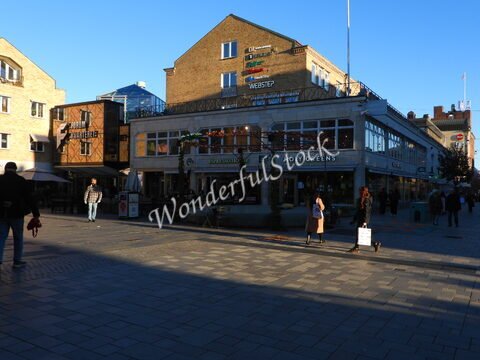 Quartier animé avec des boutiques et des cafés à Uppsala, Suède, sous un ciel bleu.
