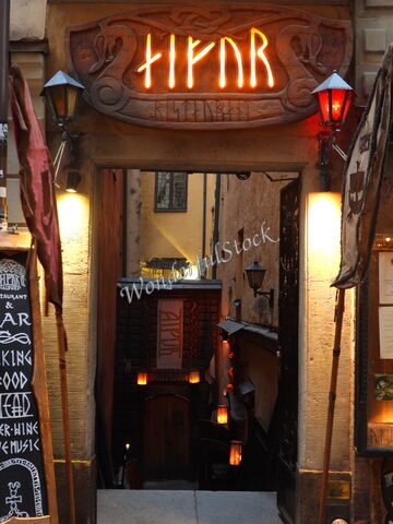 Entrée d'un restaurant à Stockholm, Suède, avec un panneau lumineux et des lanternes décoratives.