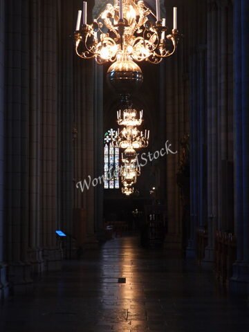 Chandeliers illuminant l'intérieur de la cathédrale d'Uppsala, Suède, avec des vitraux colorés en arrière-plan.