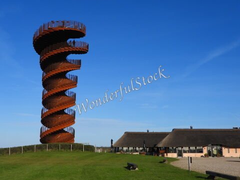 Tour en spirale à Marsk, Danemark, entourée de bâtiments à toit de chaume et d'un ciel clair.