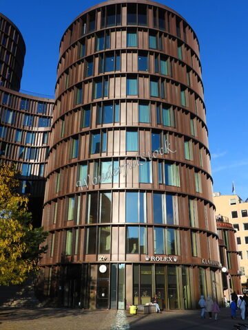 Immeuble moderne à Copenhague, Danemark, avec des façades en verre et des boutiques visibles au rez-de-chaussée.