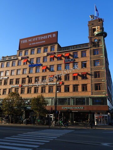 Bâtiment avec le Scottish Pub et des enseignes de restaurants à Copenhague, Danemark, sous un ciel bleu.