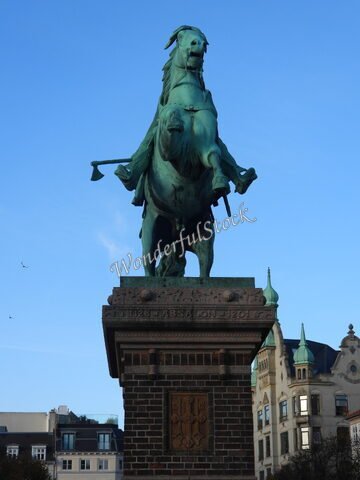 Statue équestre à Copenhague, Danemark, avec un ciel bleu et des bâtiments historiques en arrière-plan.