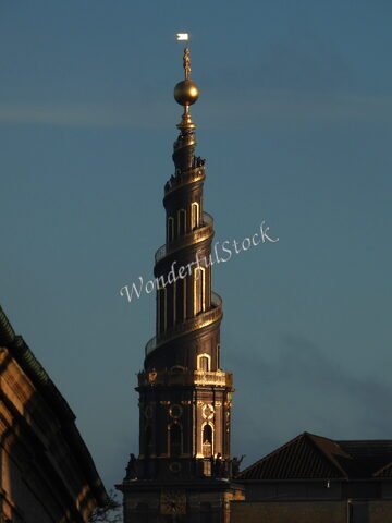 Cloche de la tour spirale à Copenhague, Danemark, surplombée d'une statue dorée et d'un globe doré.