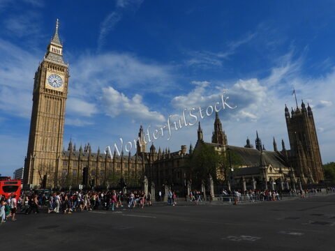 Big Ben et le palais de Westminster à Londres, Angleterre, avec des passants et un ciel nuageux.