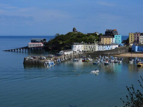 Port de Tenby au pays de Galles, avec des bateaux amarrés et des maisons colorées en arrière-plan.