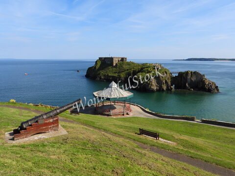 Un canon et un kiosque surplombent la mer à Tenby, au pays de Galles, avec une forteresse sur l'île à proximité.