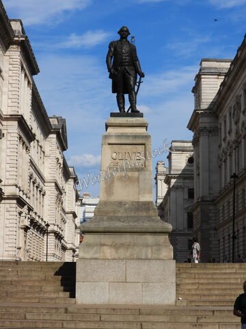 Statue de Clive sur un socle, entourée de bâtiments historiques, à Londres, Angleterre.