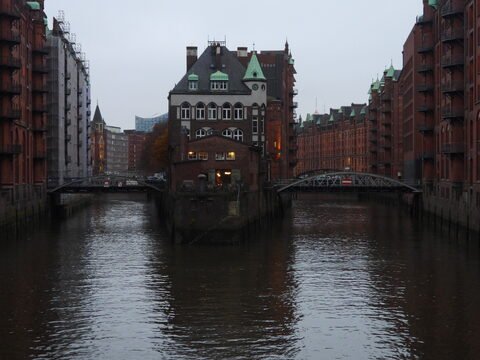 Un bâtiment au bord de l'eau et des ponts, à Hambourg, Allemagne, entouré de constructions en briques.