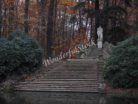 Escalier en pierre avec une statue au sommet, entouré de verdure et d'automne, en Allemagne.