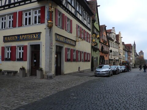 Édifices colorés avec enseignes en bois dans une rue pavée à Rothenburg, Allemagne.