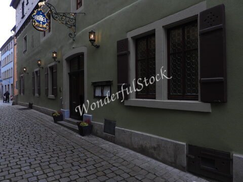 Hôtel avec une enseigne, fenêtres à volets, sur une ruelle pavée à Rothenburg, Allemagne.