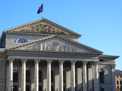 Théâtre avec colonnes et fresques, Munich, Allemagne. Un drapeau flotte au sommet du bâtiment.