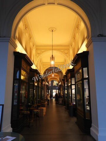 Passage avec des boutiques à Hambourg, Allemagne, présentant des arches élégantes et un éclairage doux.