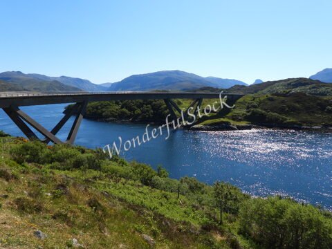 Pont moderne sur une rivière entourée de collines verdoyantes en Écosse.
