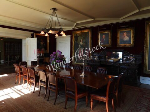 Salle à manger avec une grande table en bois, des portraits accrochés aux murs, Château de Dunvegan, Écosse.