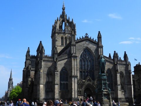 Édifice gothique à Édimbourg, Écosse, avec une statue au premier plan et des détails architecturaux distinctifs.