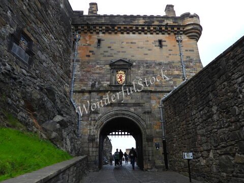 Entrée du château à Édimbourg, Écosse, avec des murs en pierre et un blason au-dessus de l'arcade.