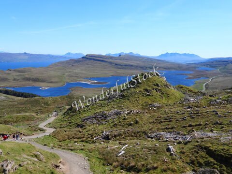 Vallée verdoyante et lacs en Écosse sur l'île de Skye, avec des collines et un chemin sinueux au premier plan.