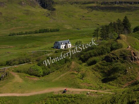Maison blanche entourée de collines verdoyantes sur l'île de Skye, Écosse.