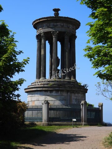Monument en pierre avec colonnes, entouré d'arbres, situé à Édimbourg, Écosse.