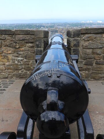 Canon en métal noir avec vue sur Édimbourg, Écosse, et ses bâtiments historiques en arrière-plan.
