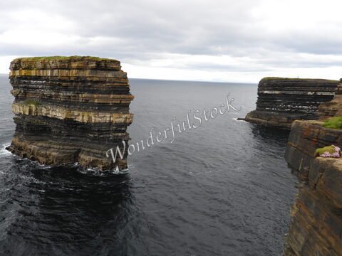 Falaises côtières à Downpatrick Head, Irlande, surplombant l'océan, avec des formations rocheuses distinctives.